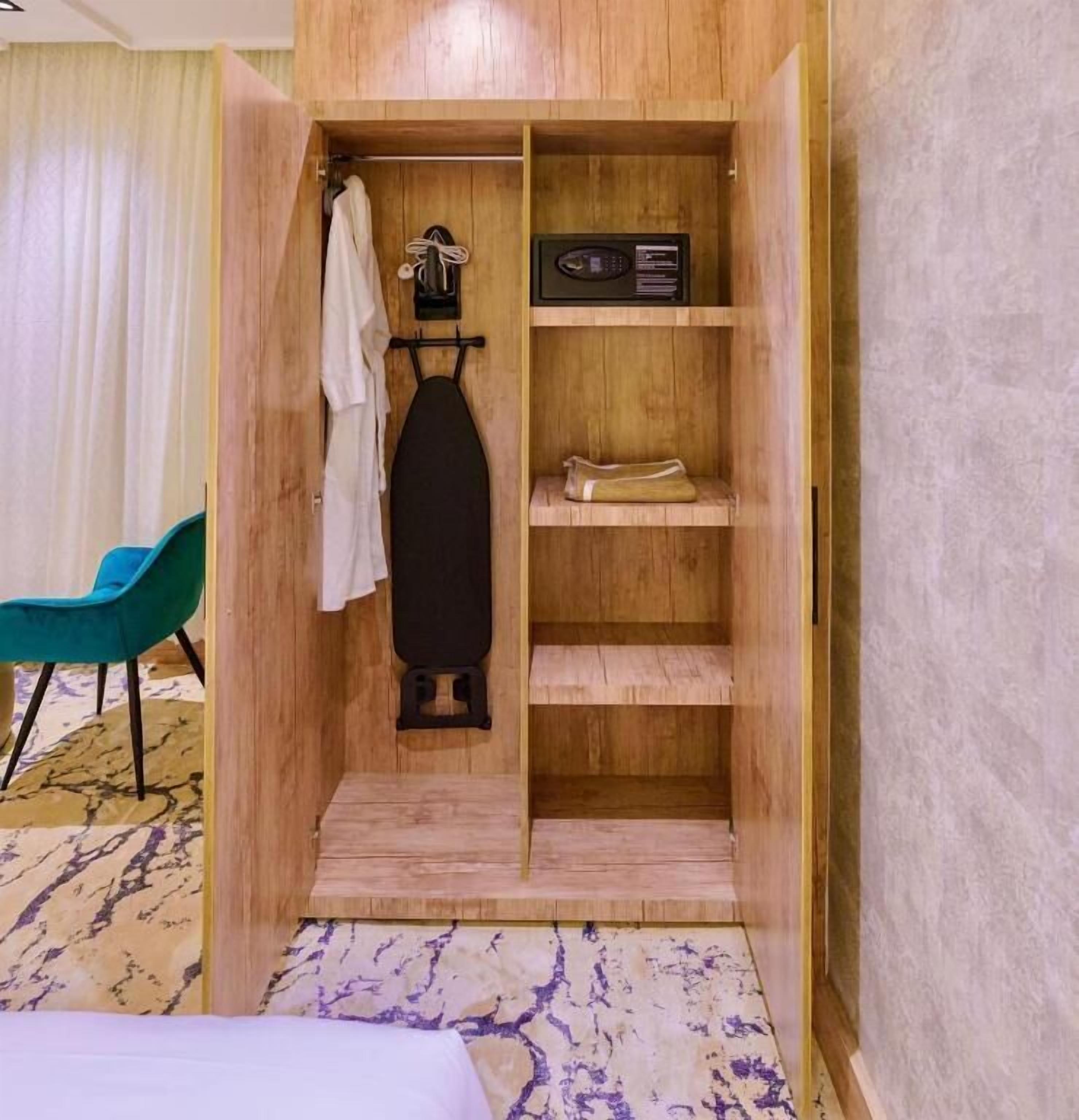 A wooden wardrobe with shelves, a hanging rack, and a radio.