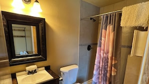 Un bagno con lavandino, WC e doccia.