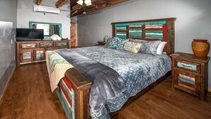 Una camera da letto con un letto in legno, una televisione su un mobile in legno e un arredamento rustico.