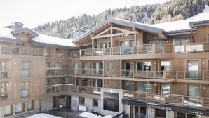 A multi-story hotel with balconies, a stone facade, and a sign for 'ANNAPURNA'. - Wifi, resort center, 1st floor, sauna, hammam, balcony, parking, tv, 82m², Les Gets (Les Gets)