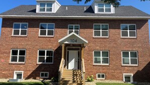A two-story brick building with a number '104' above the entrance.