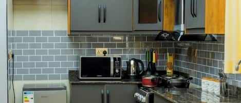 Apartamento económico, vistas a la ciudad | Cocina privada | Microondas, horno, placa de cocina y utensilios de cocina