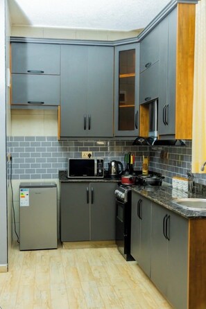 Economy Apartment, City View | Private kitchen | Microwave, oven, stovetop, cookware/dishes/utensils - Cozy Residences Kampala 002 (Kampala)