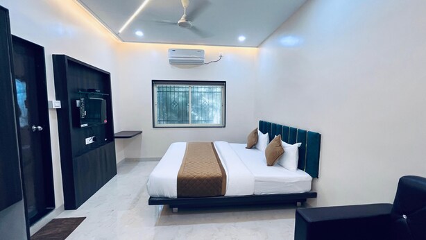 A modern hotel room with a bed, a desk, and a window.