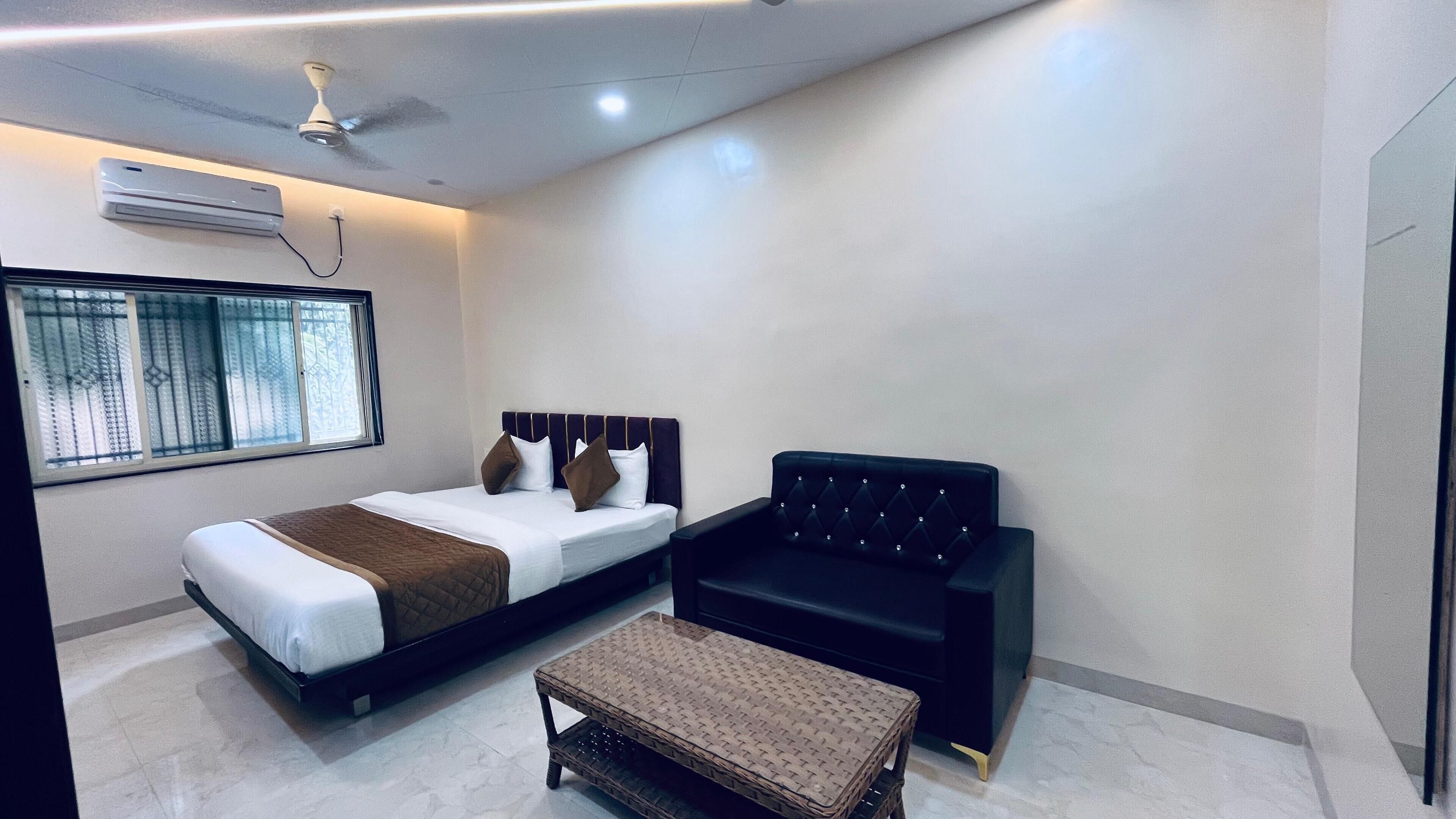 A modern bedroom with a bed, a black sofa, and a small table.