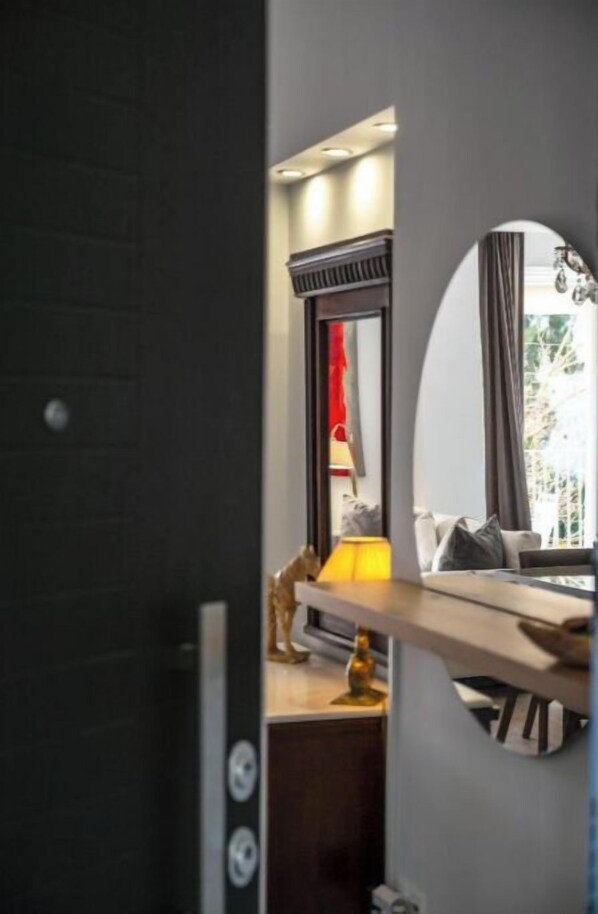 Une chambre d’hôtel moderne dotée d  ’un grand miroir, d’une table de chevet avec une lampe et offrant une vue sur l’extérieur.