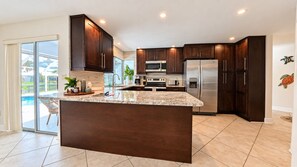 Una cocina moderna con armarios de madera oscura, electrodomésticos de acero inoxidable y una isla grande.
