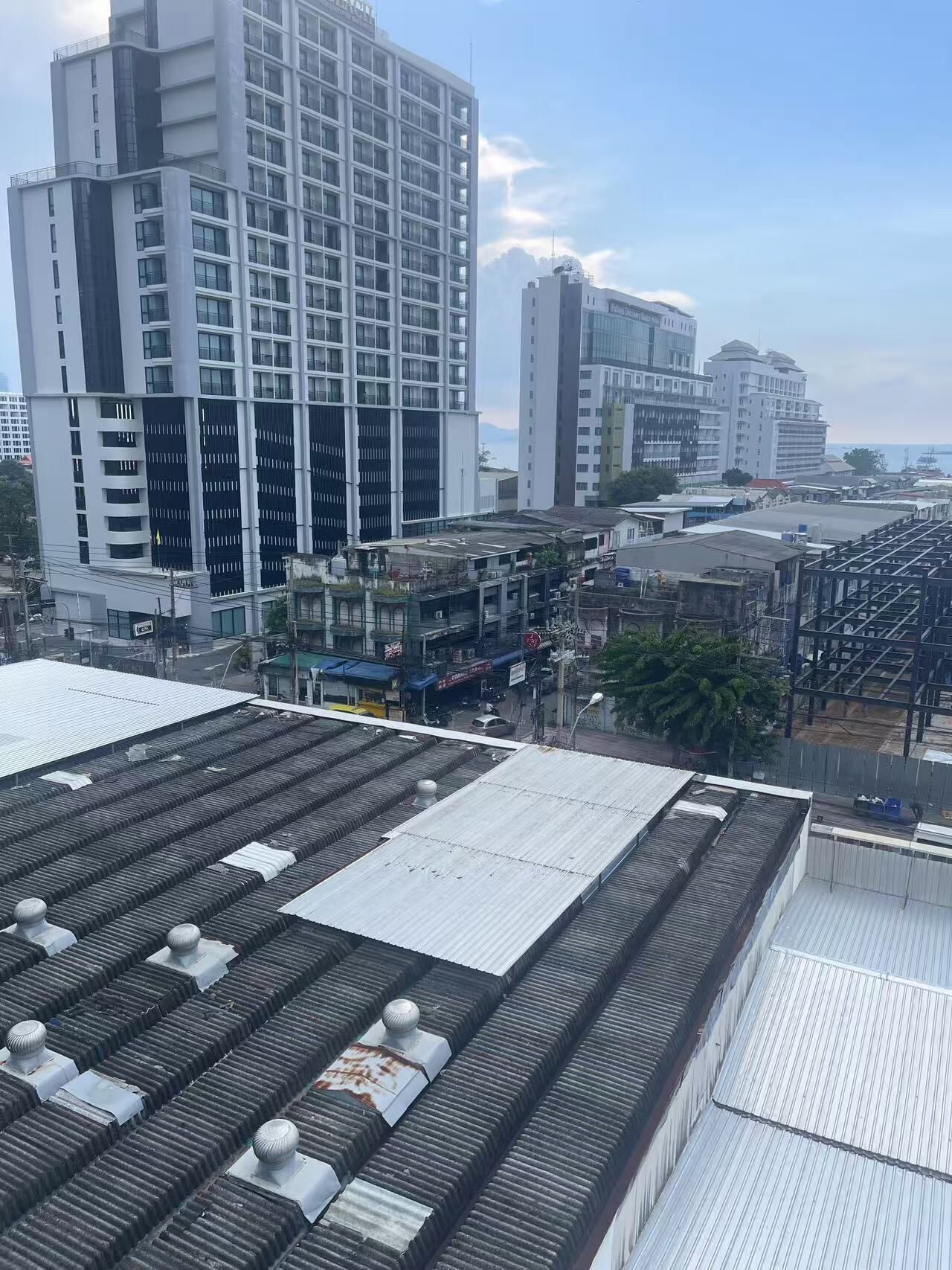 A high-rise building with a grid of windows and a flat roof with ventilation units.