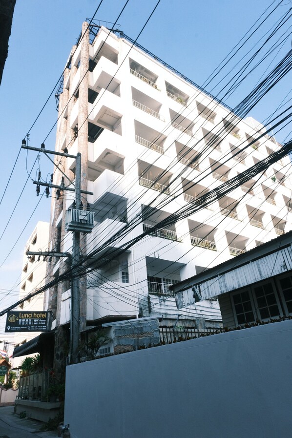 Un edificio de varios pisos con balcones y un cartel que dice Luna Hotel.