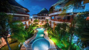 A resort with a swimming pool, multiple balconies, and lush landscaping. - Modern 3 BR Condo in PDC - Muuyal 304 (Playa del Carmen)