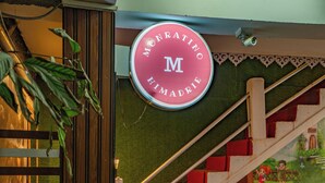 A staircase with a children's mural, a green mat at the bottom, and a sign above the stairs. - Monratino Himadrie (Darjeeling)