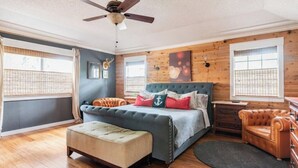 A bedroom with a bed, a bench, a dresser, and a ceiling fan. - Tranquil Family Retreat in NW Austin, Hot Tub, Office, & Backyard Escape (Austin)