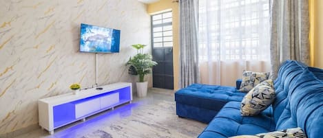Departamento Deluxe, vista a la ciudad | Área de sala de estar | Smart TV de 24 pulgadas con canales digitales