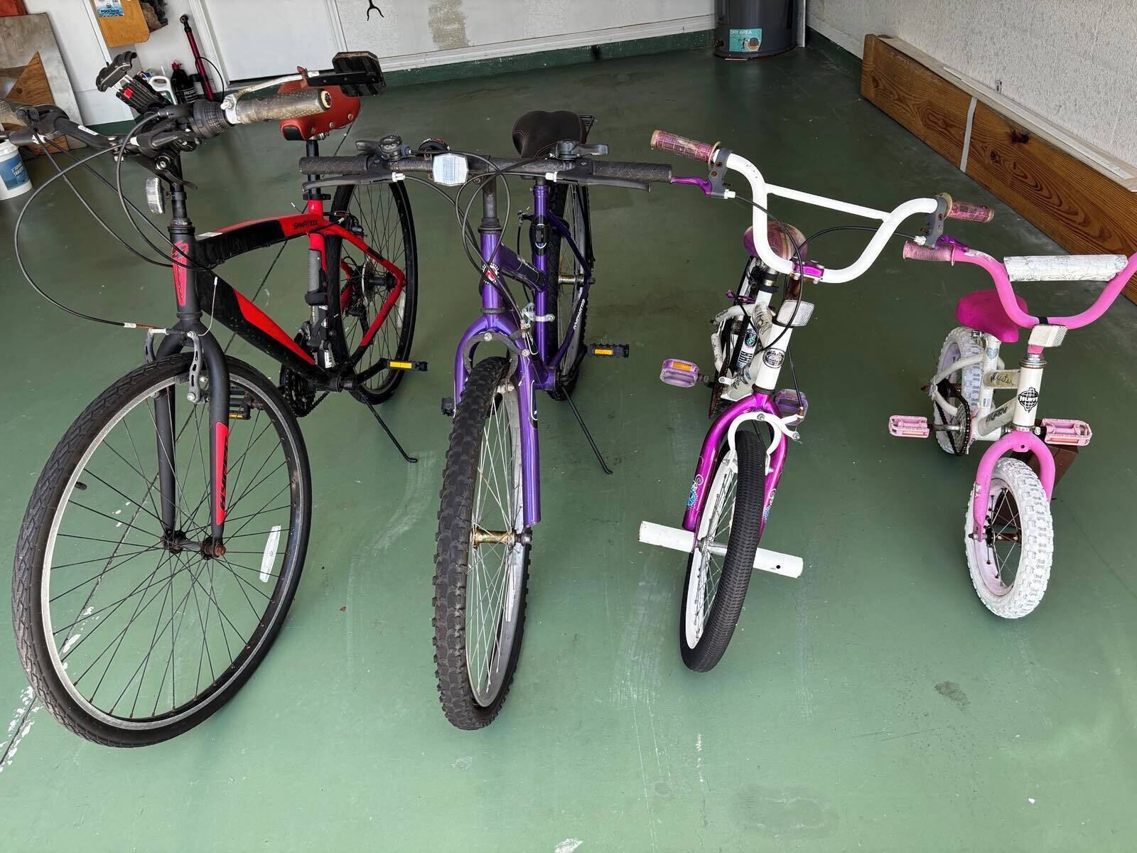 A row of bicycles parked indoors on a green floor.
