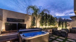 A hot tub with a built-in seating area, surrounded by a patio with outdoor furniture and a barbecue grill. - Gated,new 5bed home in Vegas Summerlin (Red Rock Casino area),w/ Hot Tub,BBQ,etc (Las Vegas)