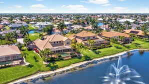 A residential area with houses, a lake, and a fountain.
