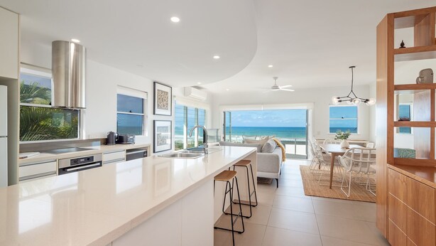 A modern kitchen with a large island, a dining area with a view, and a cozy seating area.