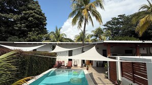 Una piscina con sillas de descanso y una valla blanca.
