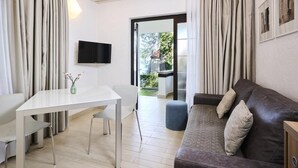 Una sala de estar moderna con una mesa blanca, un sofá de cuero marrón y un televisor montado en la pared.