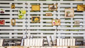 Un coin repas avec des lambris en bois blancs et des œuvres d’art encadrées accrochées au mur.