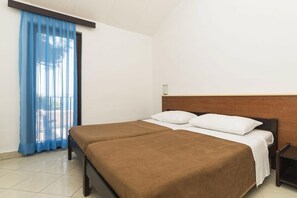 Relax in a serene space with a double bed and a nightstand, surrounded by large windows and white walls.