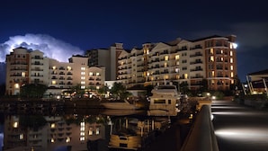 A waterfront hotel with multiple balconies, a marina with boats, and a reflection in the water. - Marina Inn Grande Dunes Condos & Suites (Myrtle Beach)