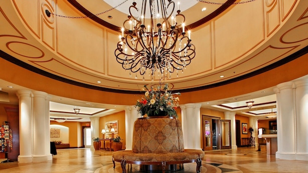 A lobby with a central round table, a chandelier, and a large floral arrangement. - Marina Inn Grande Dunes Condos & Suites (Myrtle Beach)