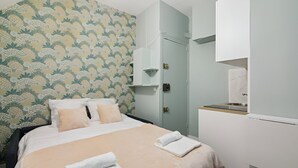 Ett hotellrum med en säng, en garderob och ett badrum.