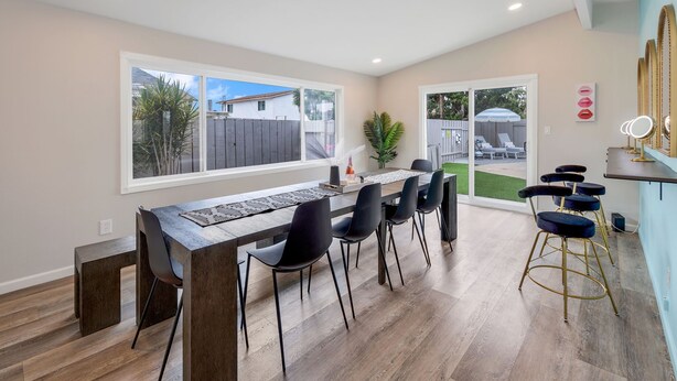 A modern dining area with a long table, black chairs, and a wooden floor. - Girls  & Family Trip+Pool+beauty bar, San Diego (La Mesa)