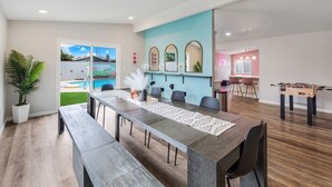 A modern dining area with a long table, chairs, and a foosball table. - Girls  & Family Trip+Pool+beauty bar, San Diego (La Mesa)