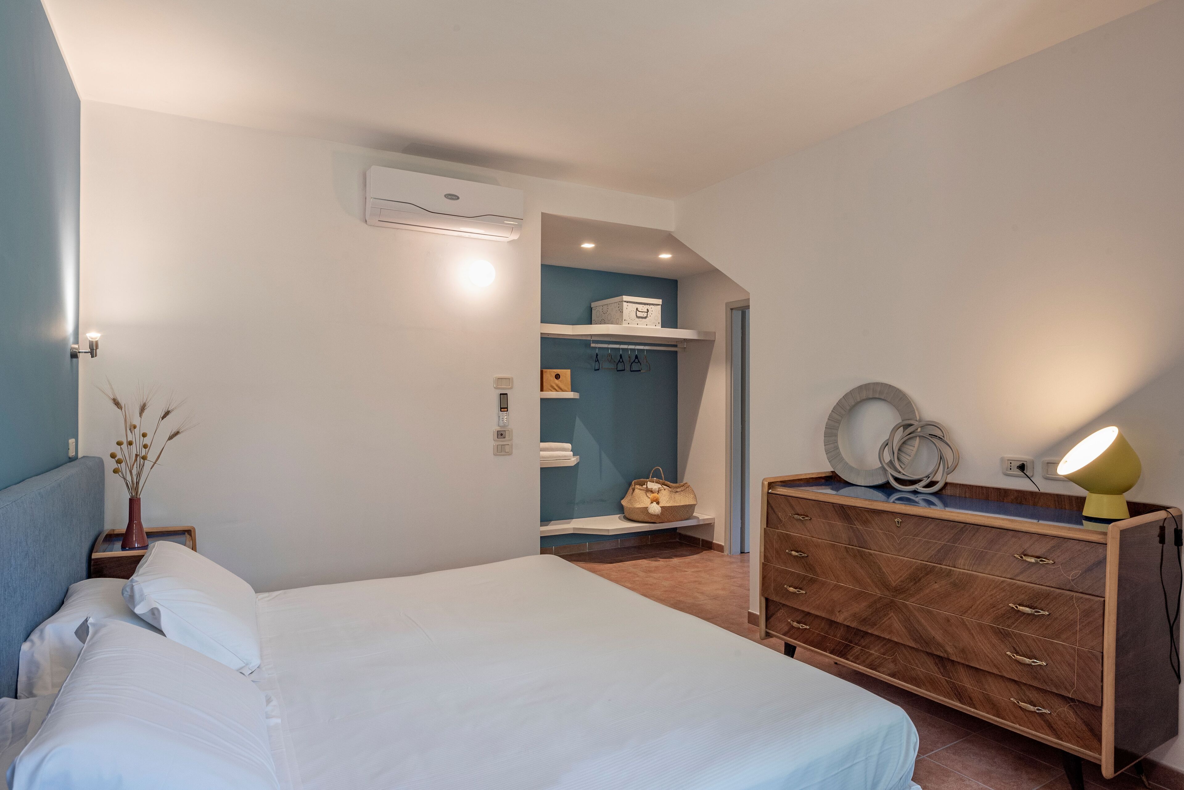 Ein Schlafzimmer mit einem Bett, einem Schminktischchen, einem Kleiderschrank und einer Kommode.