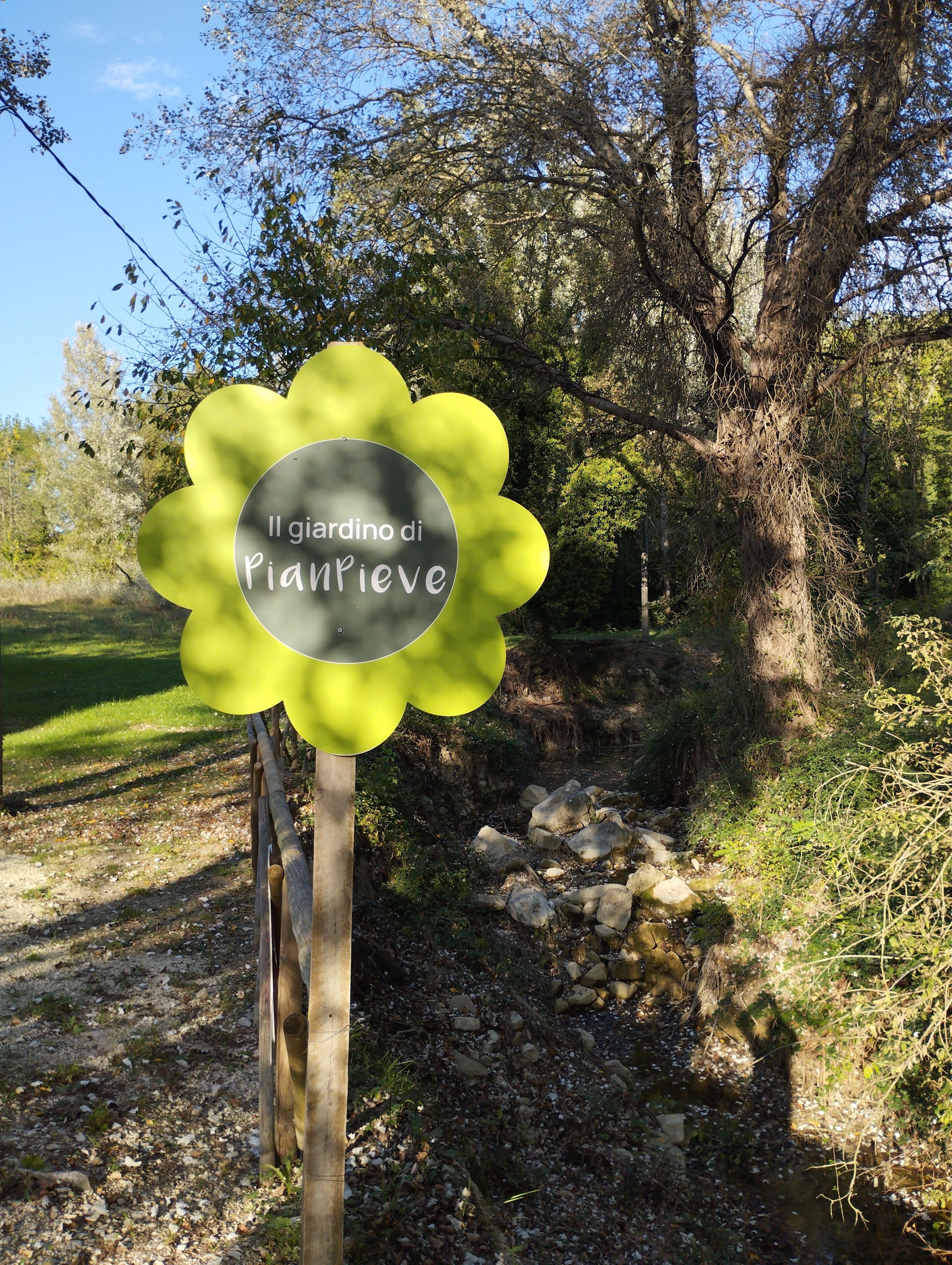 A sign with the text "Il giardino di Piantrive" in a garden setting.