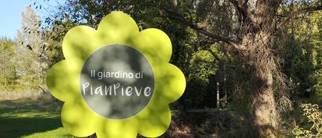 A sign with the text "Il giardino di Piantrive" in a garden setting.