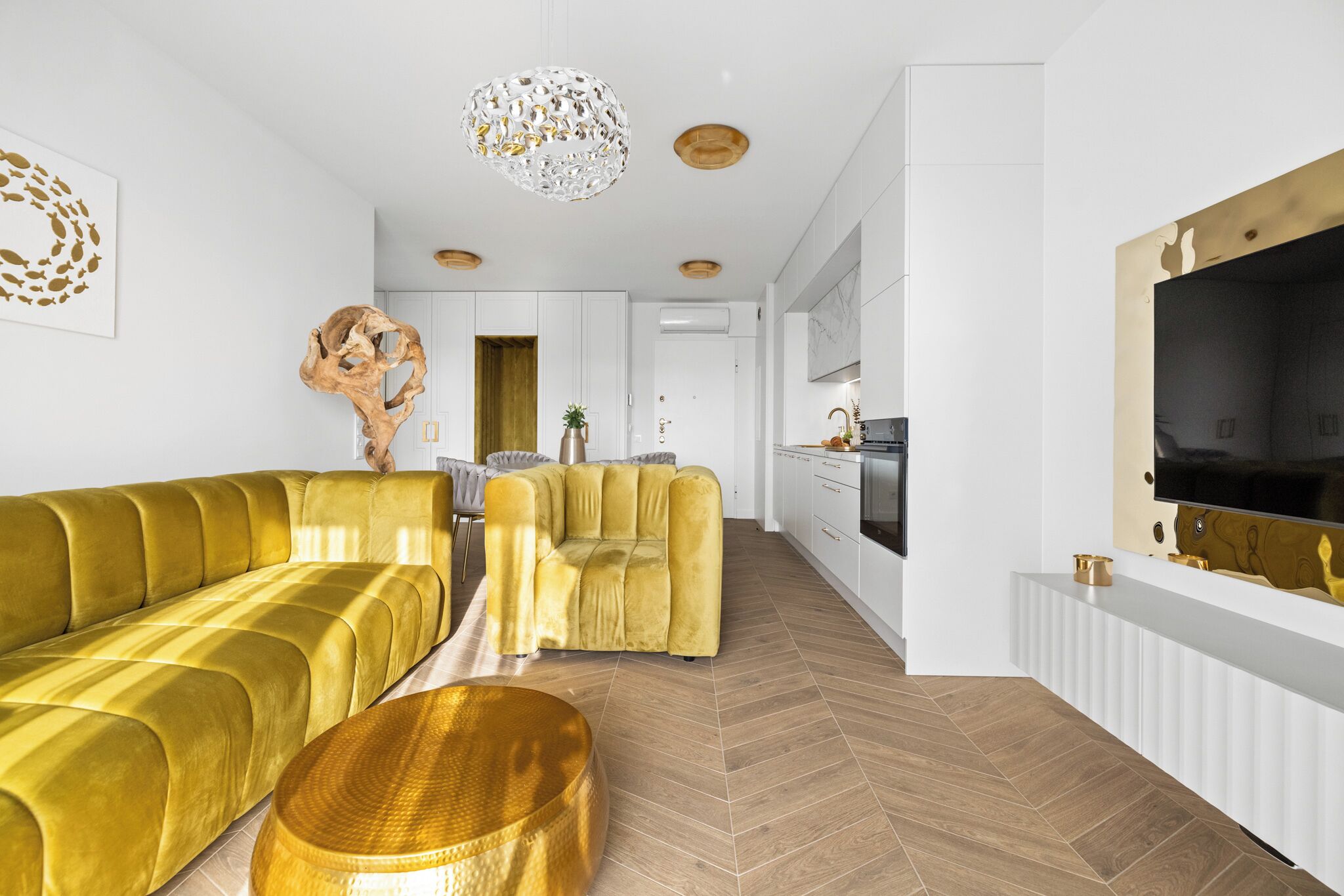 Un salon moderne avec un canapé, un fauteuil et une table basse ronde.