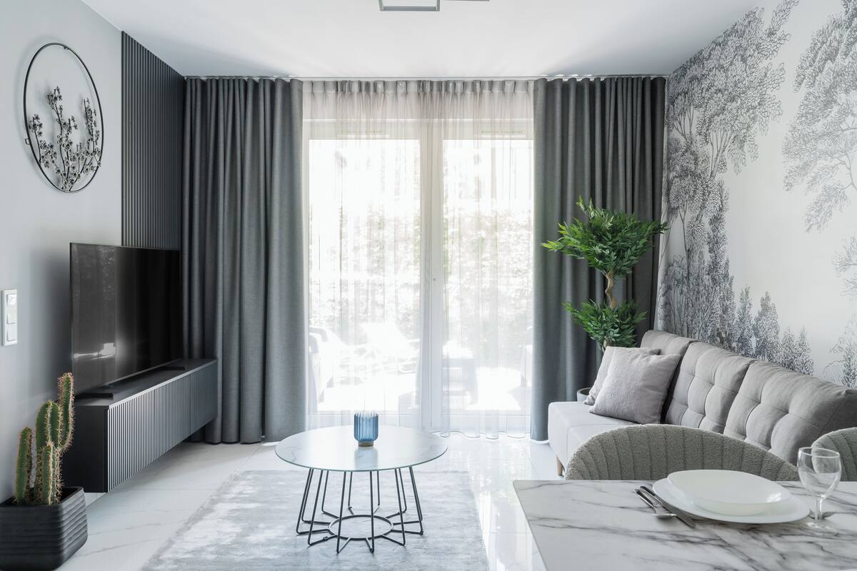 A modern living room with a sofa, a coffee table, and a TV.