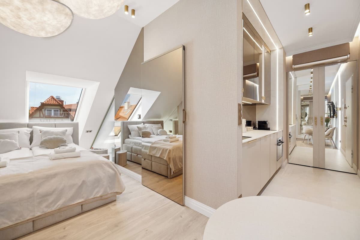 A modern bedroom with a large bed, a walk-in closet, and a view of the outside.