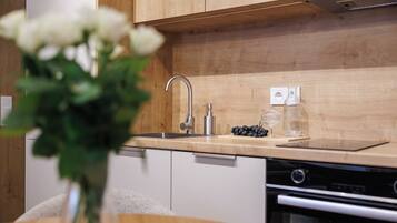 A modern kitchen with wooden cabinets, a stainless steel sink, and a built-in oven.