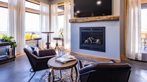Un salon moderne avec des canapés en cuir, une table basse ronde et une cheminée.