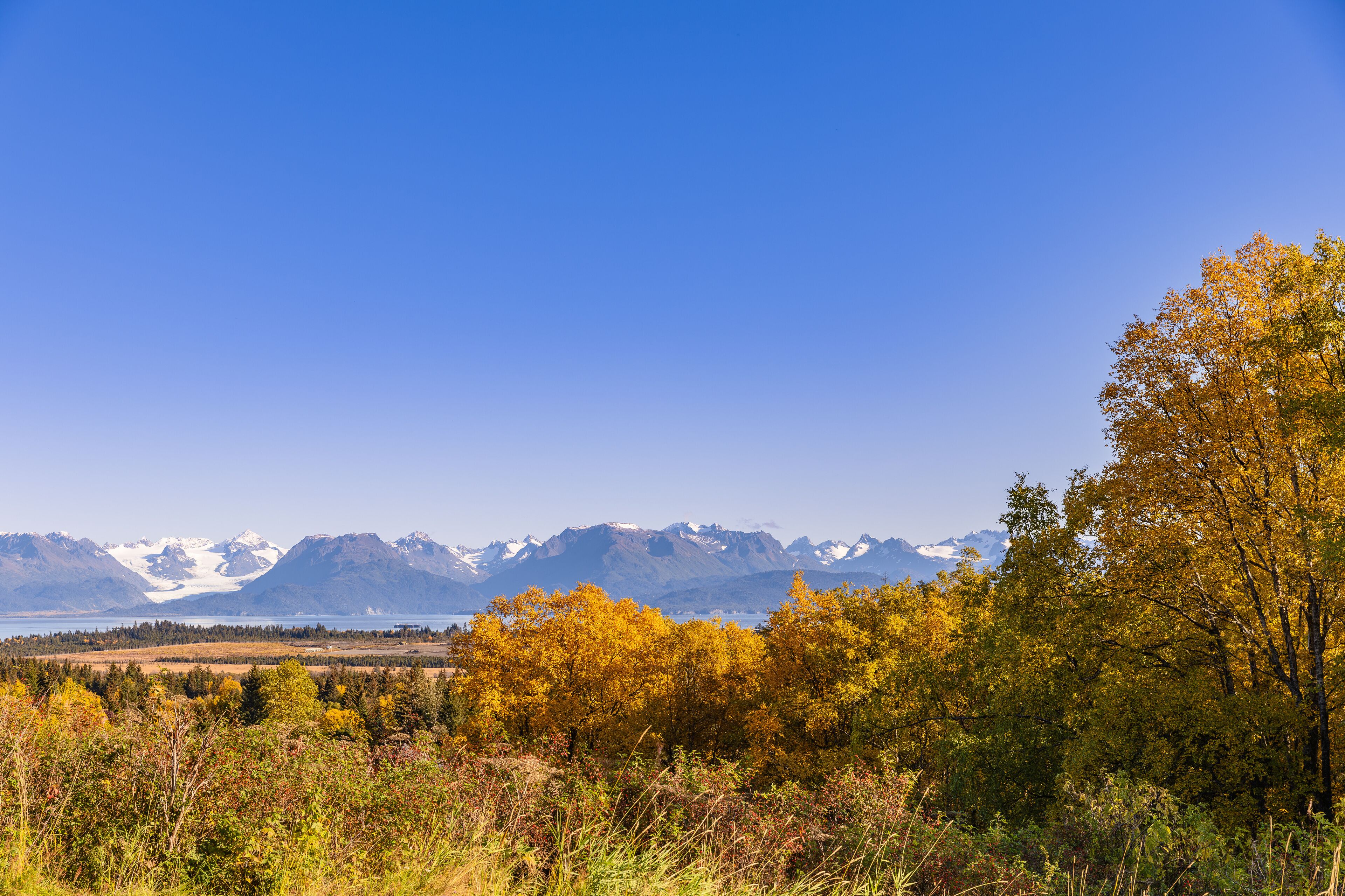 A mountainous landscape with autumn foliage and a clear sky.