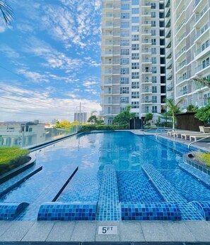 Enjoy a refreshing swim in the rooftop pool surrounded by lush greenery.