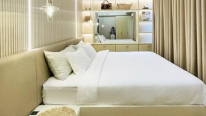 Un dormitorio moderno con una cama grande, mesitas de noche, un espejo y un armario.