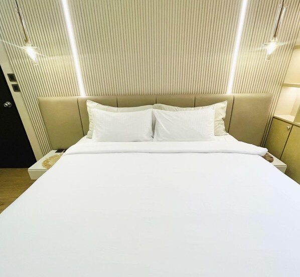 Relax in a spacious room with a large bed, white linens, and a contemporary design.
