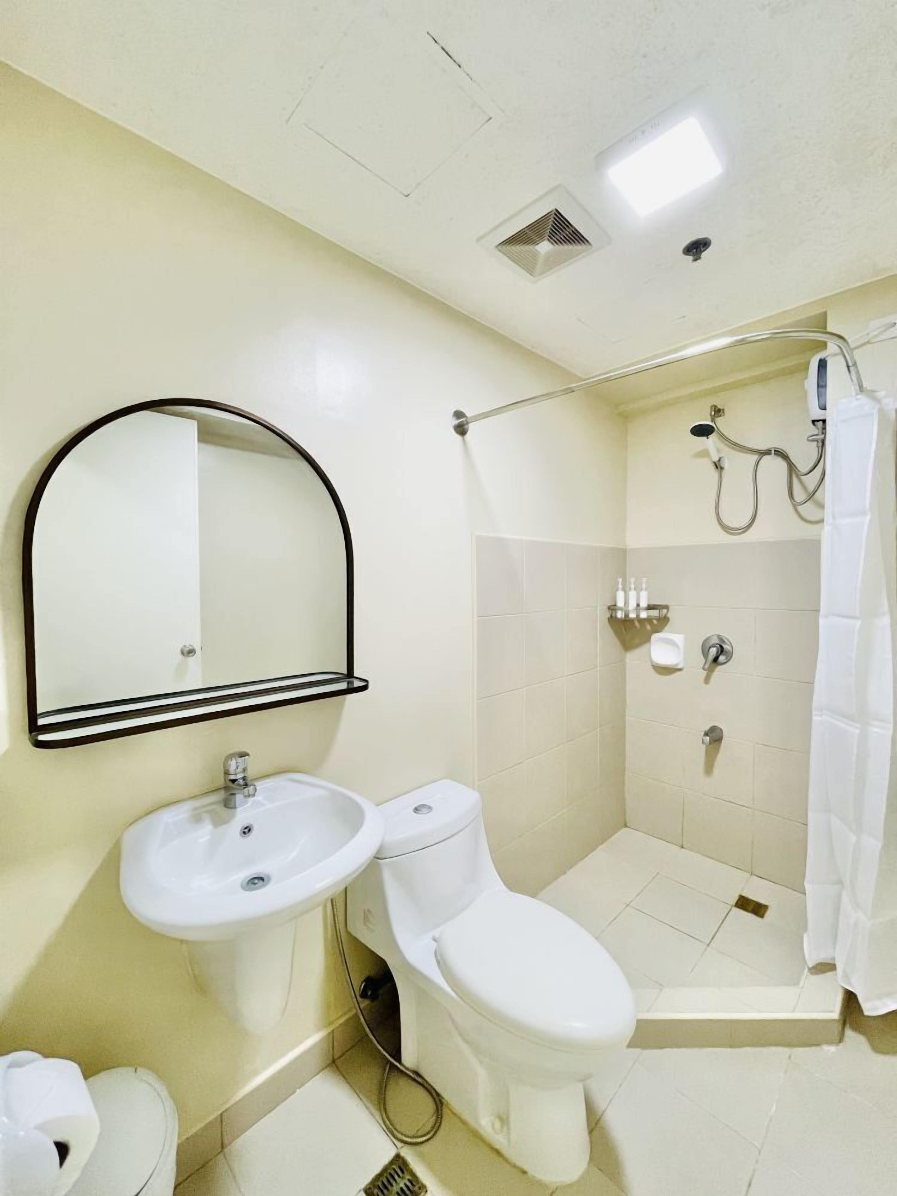 A bathroom with a sink, toilet, and shower.