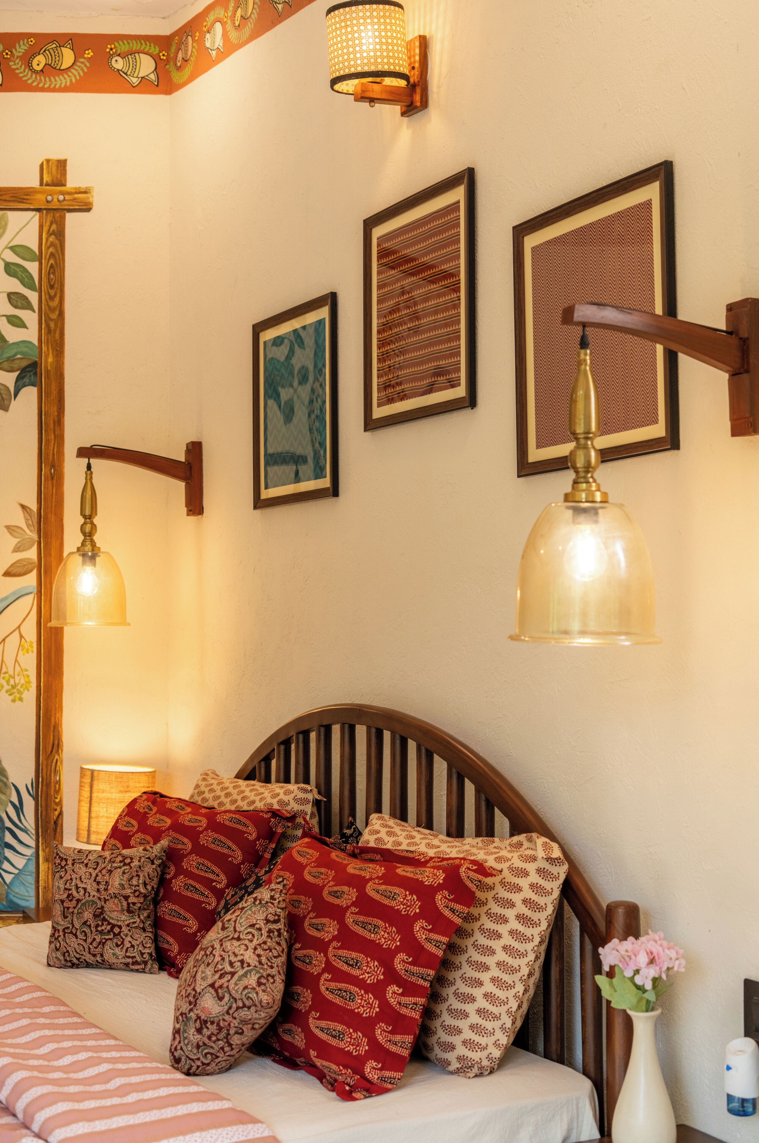 Una camera da letto con una testiera in legno, cuscini decorati e lampade a parete.