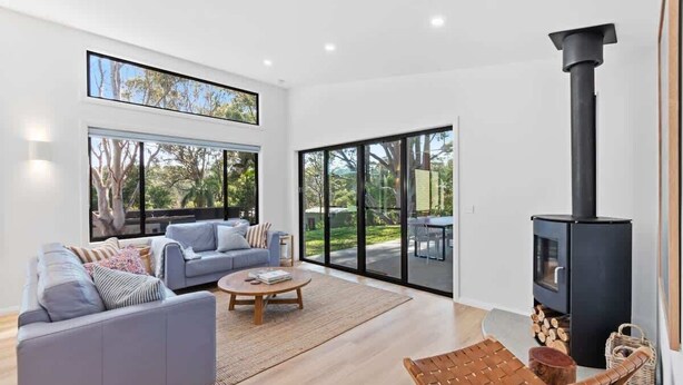 A modern living room with a sofa, coffee table, and a fireplace. - Tranquil at Rosedale (Rosedale)