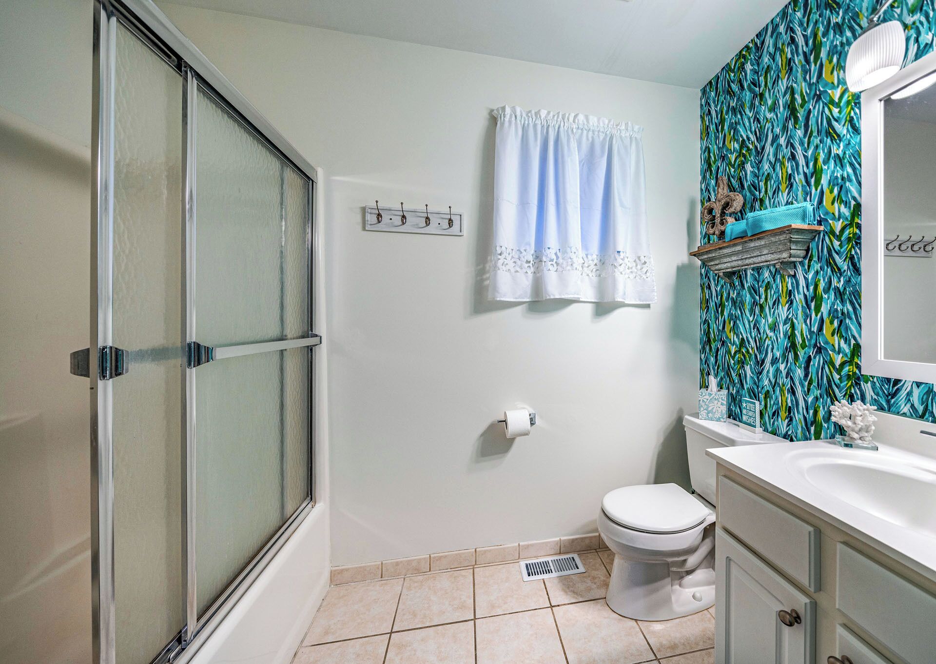Une salle de bain équipée d’une douche, de toilettes, d’un lavabo et d’un porte-serviettes.