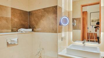 A modern bathroom with a white sink, a mirror, and a toilet.