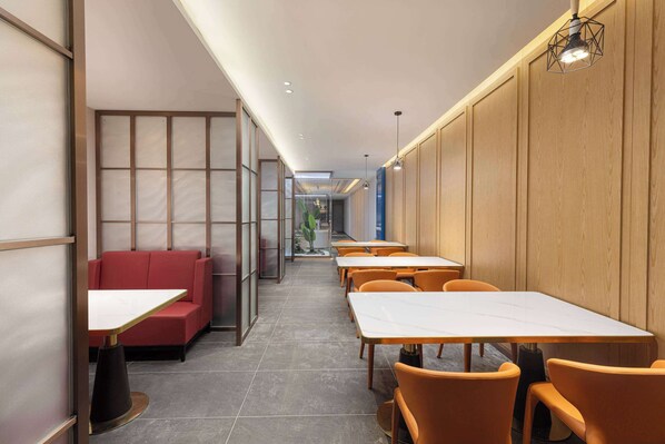 A modern restaurant interior with booths and tables, wooden paneling, and a tiled floor. - Ramada Encore By Wyndham Wuhan Station (Wuhan)