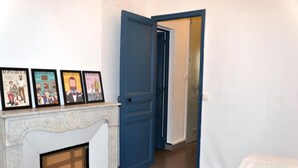 A room with a fireplace, a blue door, and a bed.