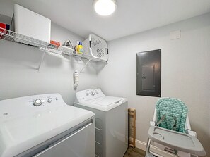 A laundry room with a washing machine, dryer, and a baby changing station.